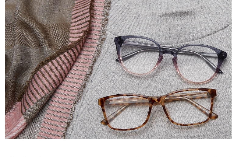 Round acetate glasses #4440112 in translucent gray-and-pink ombre and tortoiseshell rectangle glasses #2023625 folded on top of a light gray cashmere sweater and pink-and-gray scarf.
