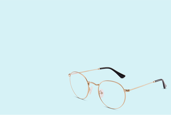 Gold round glasses on a light blue background.