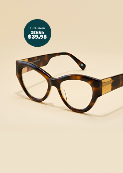 Tortoiseshell cat-eye sunglasses with thick temple arms with gold detailing, on a beige background.