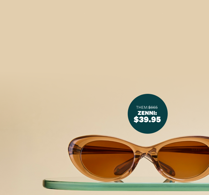Brown transparent cat-eye sunglasses with brown lenses, sitting on a glass shelf on a beige background.