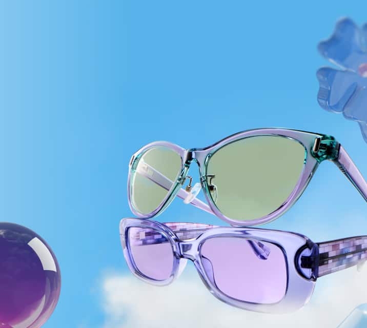 Two pairs of translucent glasses floating in a blue sky with light clouds, including a teal-to-purple gradient frame with light green lenses and a solid purple frame with purple lenses, surrounded by 3D shapes.