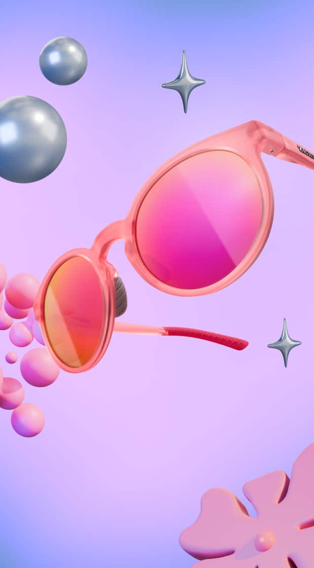 Translucent pink round sunglasses with vibrant pink mirrored lenses floating in a surreal dreamscape with glossy silver spheres, a stylized pink flower, and abstract bubbles against a purple and blue gradient background.