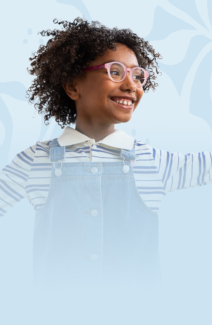 Smiling child wearing pink and purple eyeglasses from the Zenni Vision of Wellness collection, dressed in a striped shirt and denim overalls, with arms raised against a light blue background.