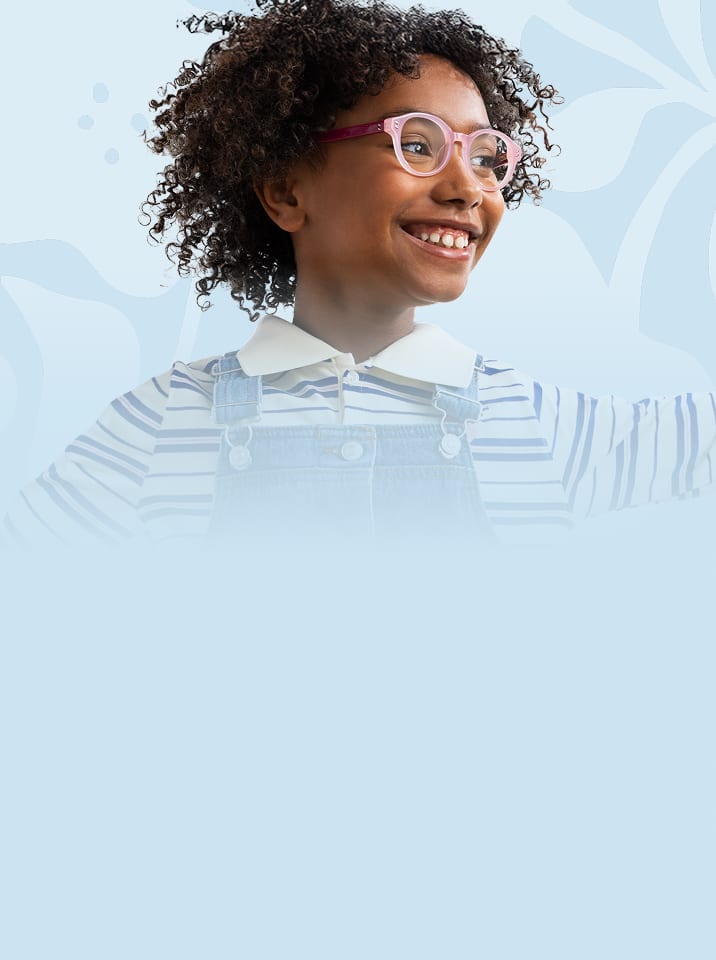 Smiling child wearing pink and purple eyeglasses from the Zenni Vision of Wellness collection, dressed in a striped shirt and denim overalls, with arms raised against a light blue background.