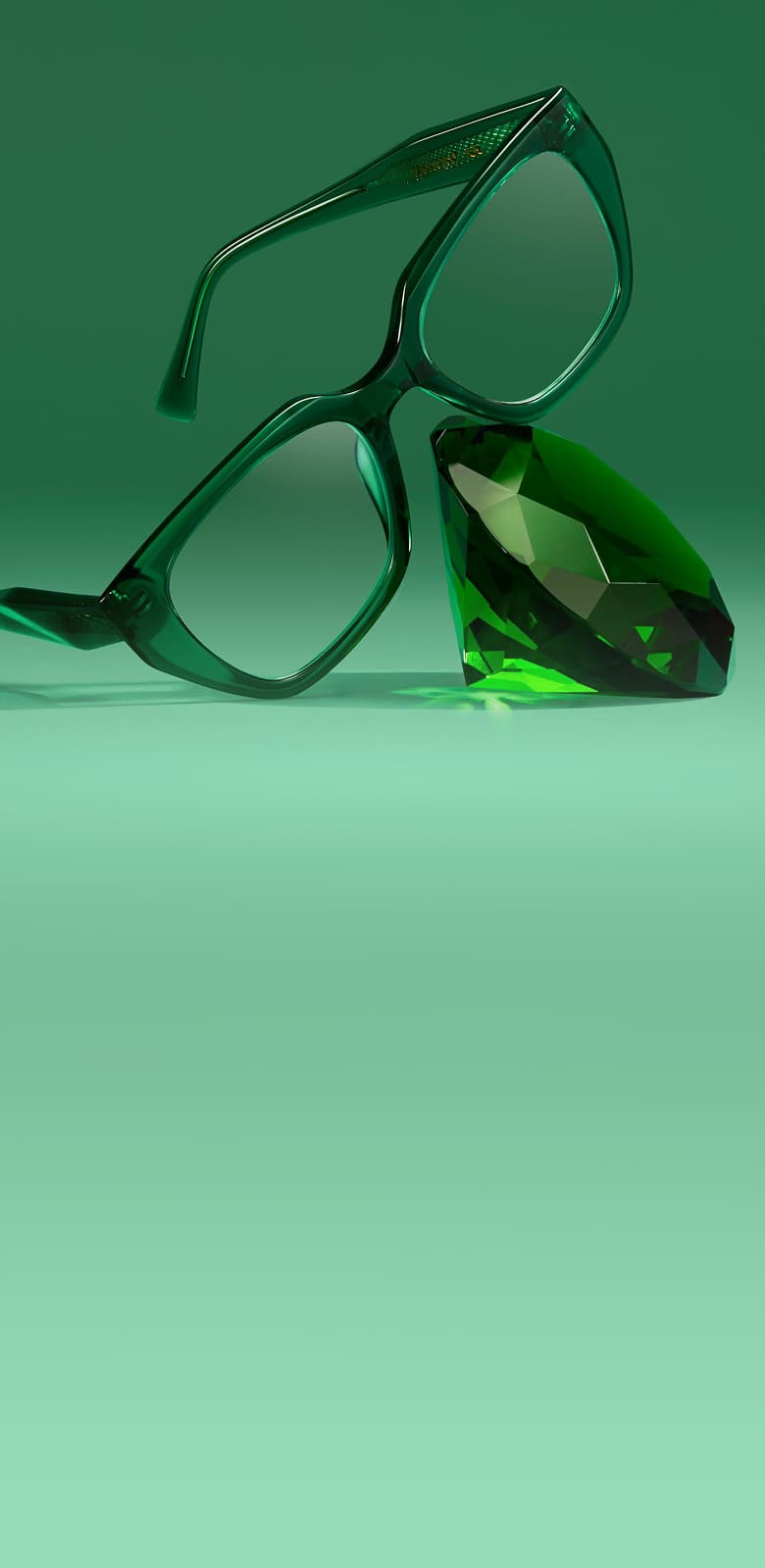 Emerald green translucent eyeglasses angled on a matching green background leaning against a large faceted green jewel.
