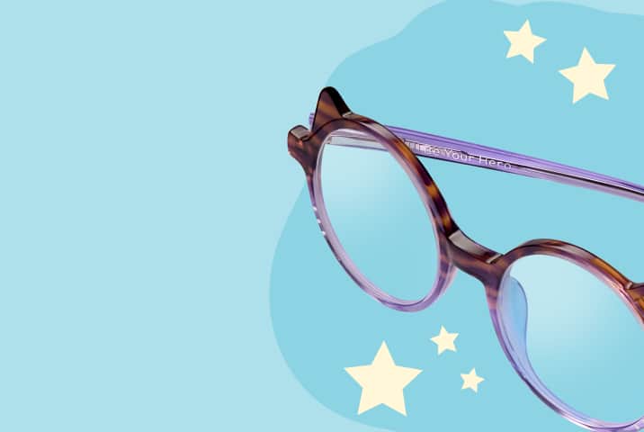 Lentes redondos Zenni de carey y color púrpura grabadas con la frase "Sé tu héroe" sobre un fondo verde azulado claro con estrellas.