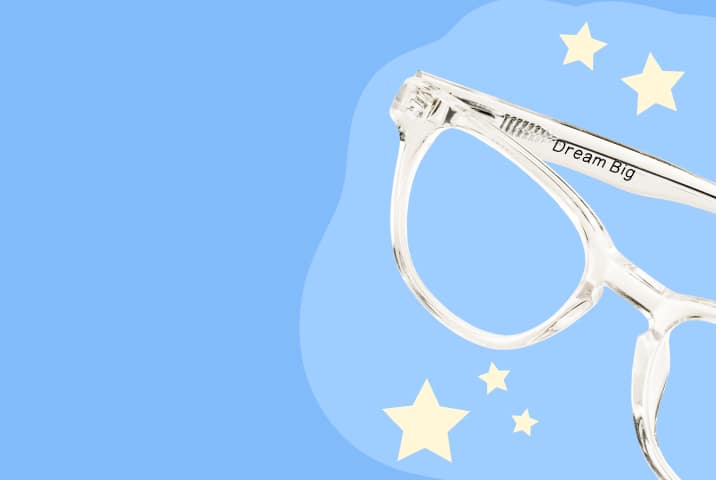 Clear kids' Zenni glasses engraved with "Dream Big," against a cloudy sky background.