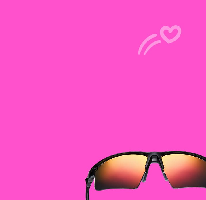 Black Zunnies sports sunglasses with mirrored amber lenses on a bright pink background with a small heart-shaped motion graphic.