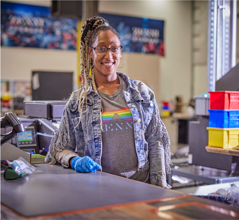 A Zenni employee taking care of packaging is smiling at the camera.