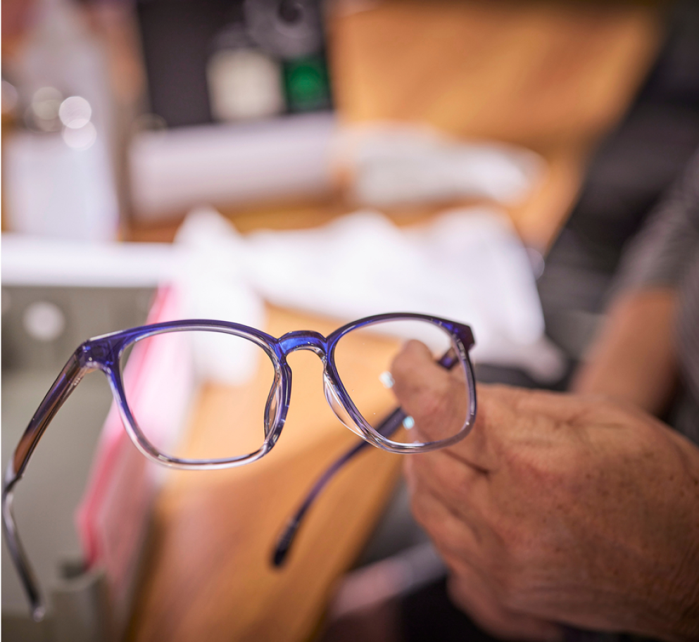 Someone inspecting a pair of glasses.