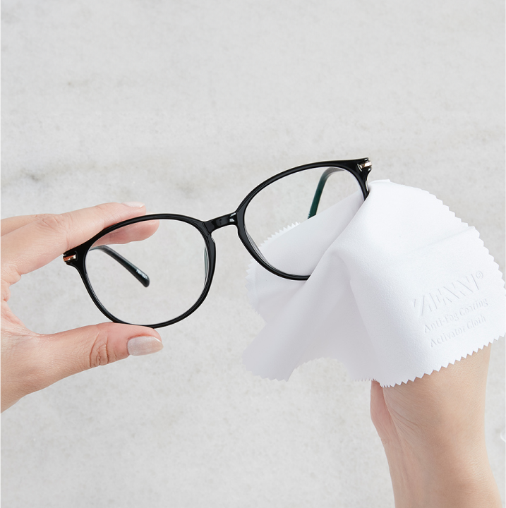 Image of the person wiping the glasses with Zenni's Anti-fog Activiator Cloth.