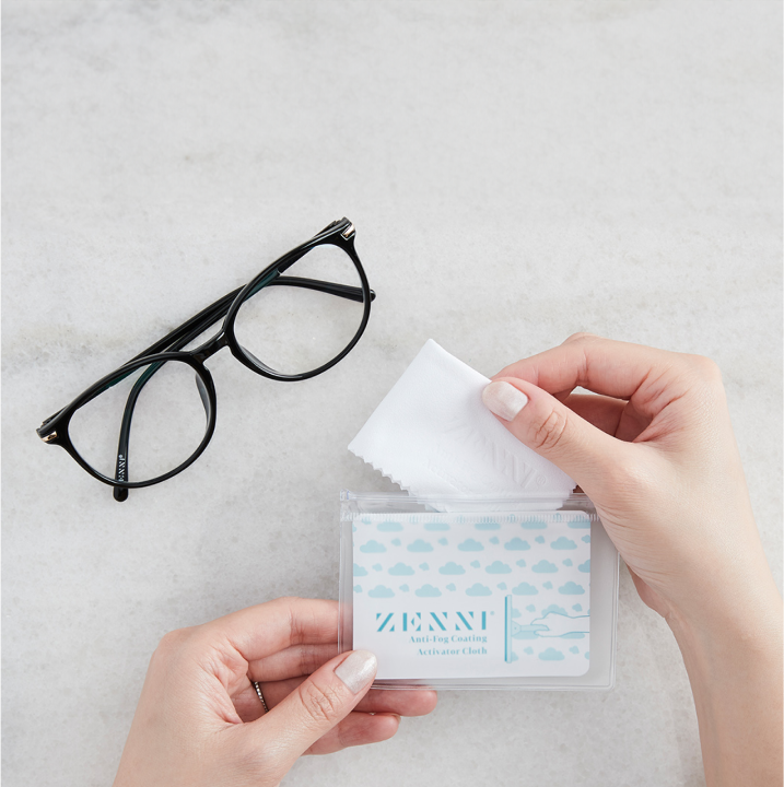 Image of a pair of Zenni glasses and the person putting the Zenni's Anti-fog Activator Cloth back to the original, resealable pouch.