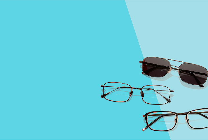 Three pairs of eyewear on a diagonal two-tone blue background: black sunglasses, slim brown rectangular glasses, and a wider brown pair with striped temple tips.