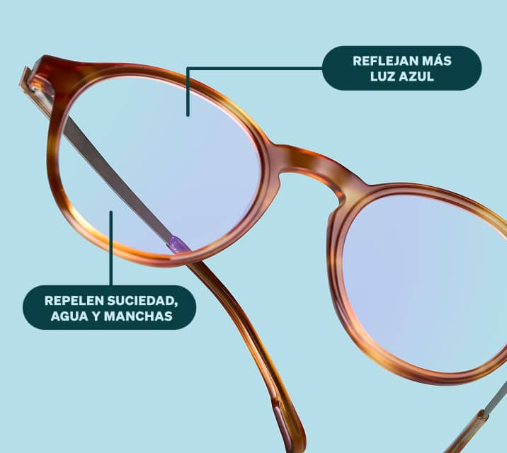 Lentes redondos Zenni de color marrón translúcido flotando sobre un fondo azul claro. Las lentes transparentes tienen un ligero brillo reflectante azul. Texto adicional: Refleja más luz azul. Repele la suciedad, el agua y las manchas.