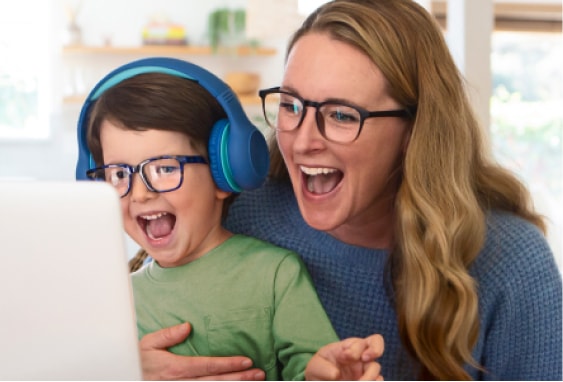 Image of a mom and kid enjoying themselves together in front of a laptop, both wearing Zenni glasses with blokz lenses.