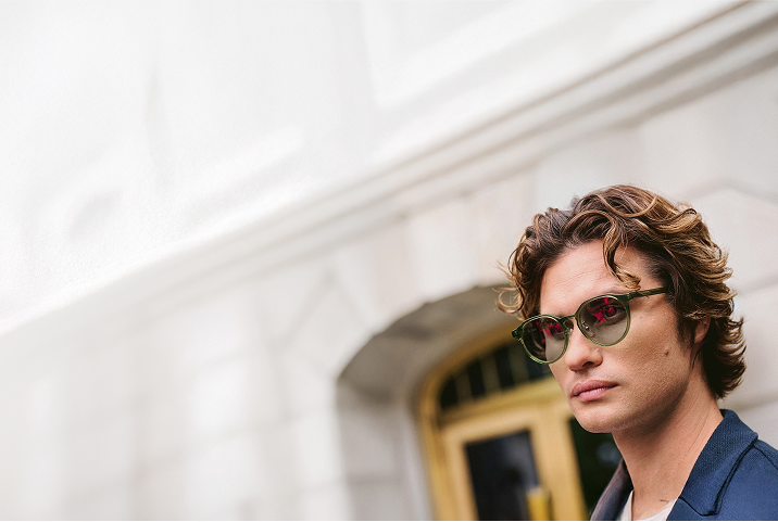 Chase Stokes wears Zenni frames featuring EyeQLenz with Zenni ID Guard lenses in an outdoor scene.