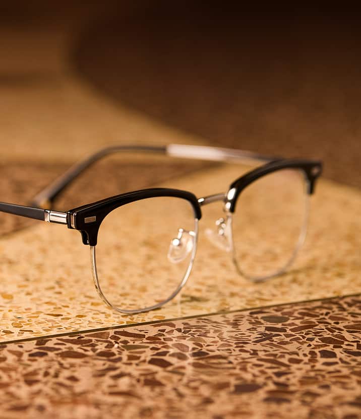 Zenni browline glasses from the Chase Stokes Collection resting on a terrazzo surface.