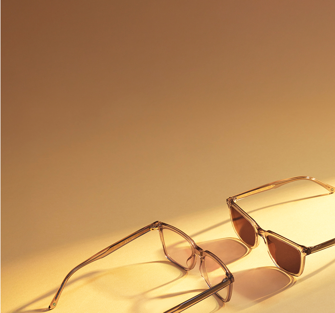 Clear “Zen Mode” Zenni square glasses, also available in sunglasses, photographed on a light golden surface casting shadows in the warm light.