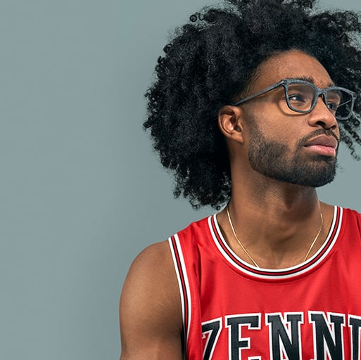 Coby White in a red Zenni basketball jersey, wearing Zenni square glasses #2026616, against a gray background.