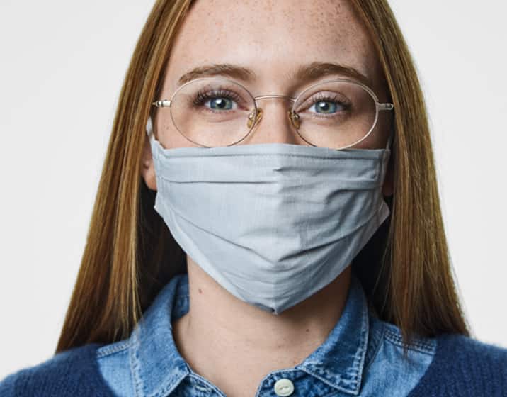 Image of an icon for a fog cloud. Image of a woman wearing face mask wearing round glasses.