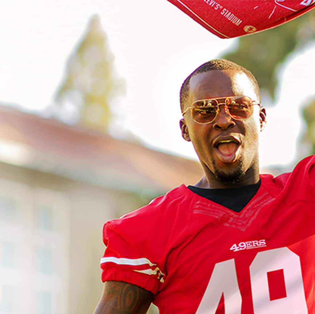 Image of a man wearing Zenni presidio aviator glasses #1127814, outside, waving a 49ers flag.