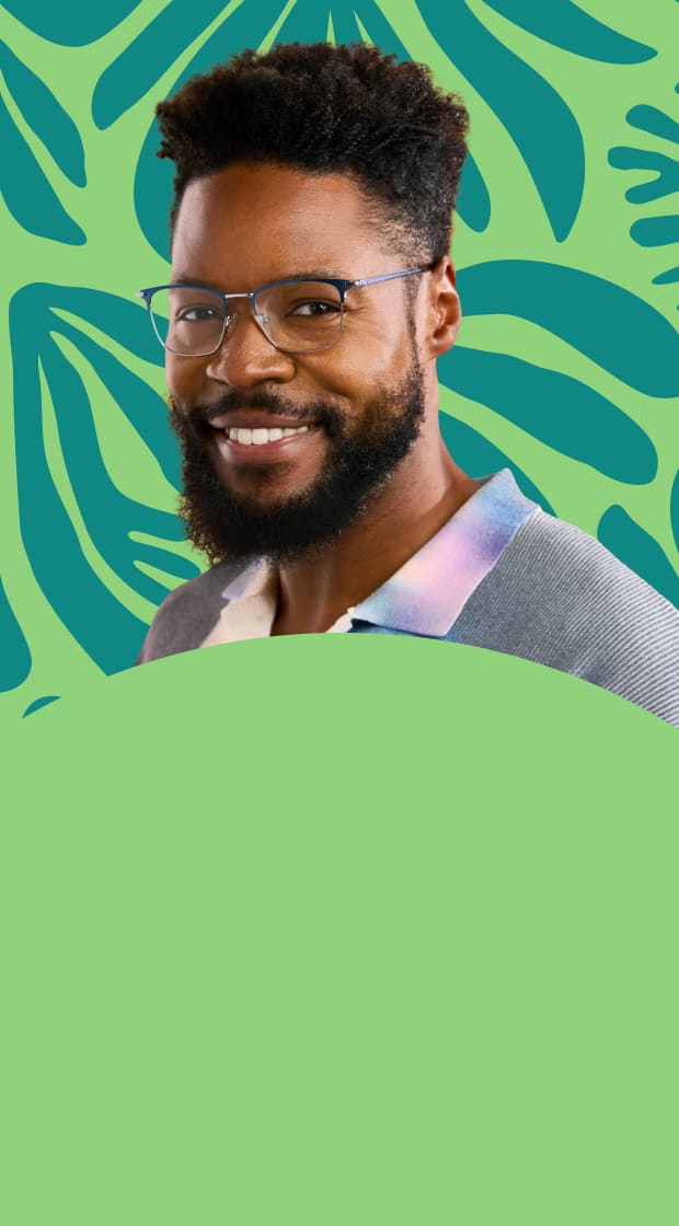 Smiling man wearing Zenni eyeglasses against a green palm-patterned background.
