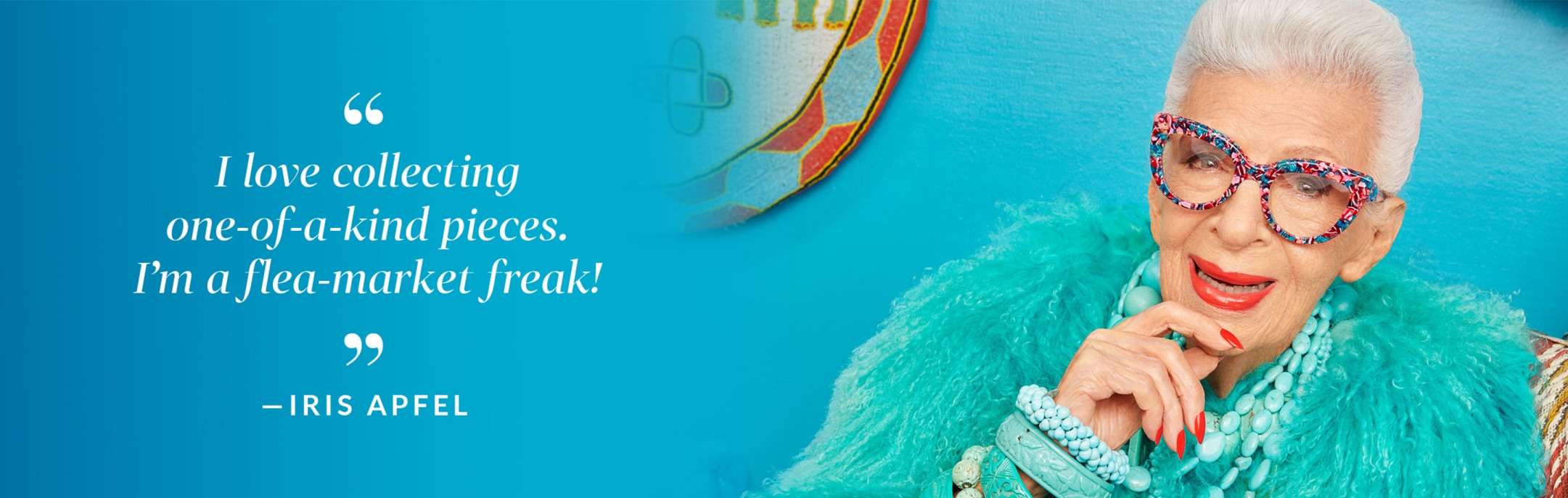 ‘I love collecting one-of-a-kind pieces. I’m a flea-market freak!’ -Iris Apfel. Image of Iris Apfel wearing Zenni cat-eye glasses #4412639 against a blue background with ethnic art behind her.