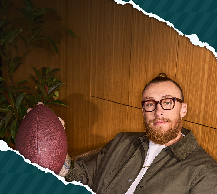 George Kittle posing with a football in bold black-rimmed rectangular glassesPlaybook from the Kittles × Zenni collection, styled with a laid-back sporty look.