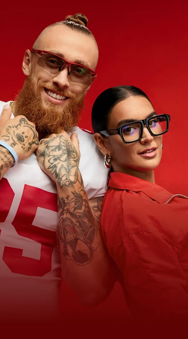 George Kittle usando lentes de sol Zenni con marco rojo y Claire Kittle usando lentes negros cuadrados marca Zenni, sobre un fondo rojo.