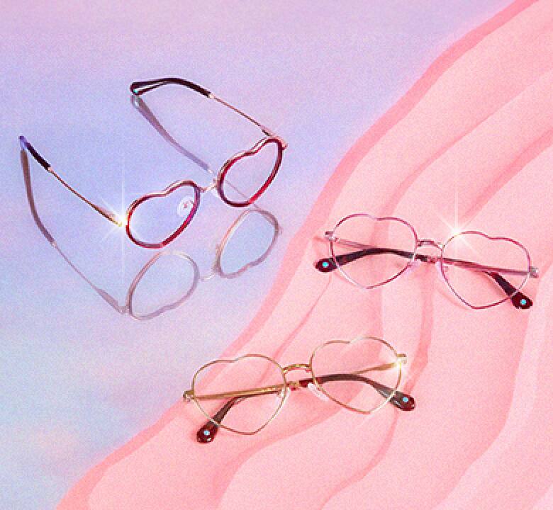 Three pairs of heart-shaped glasses on a pastel purple and pastel pink background.