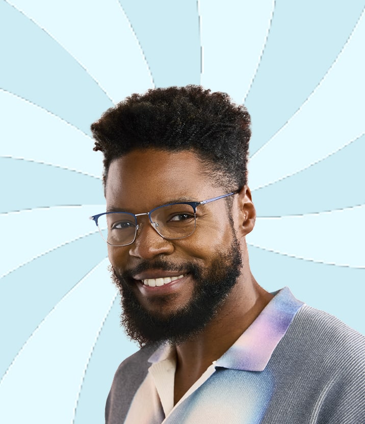 A man with dark brown curly hair and a beard, wearing blue metal square glasses, on a light blue background with a swirl motif.