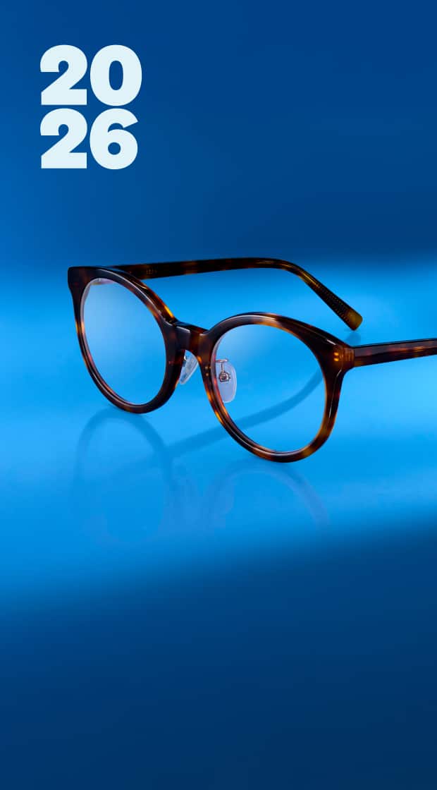 A pair of round, tortoise-shell patterned glasses resting on a reflective blue surface with the numbers ‘2026’ displayed in the top corner.