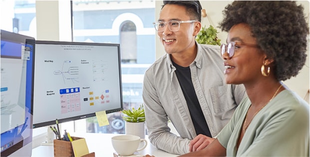 Image of two people wearing Zenni progressive glasses in front of a computer screen.