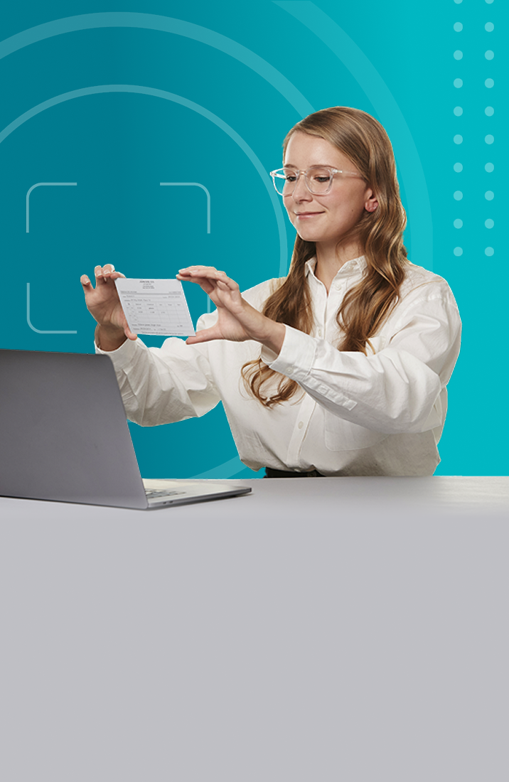 Woman holding her written prescription in front of her laptop’s camera.