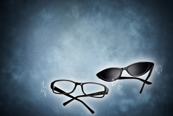 Two pairs of black glasses—one cat-eye pair of sunglasses and one rectangular optical frame—are displayed on a blue textured background with doodle accents.