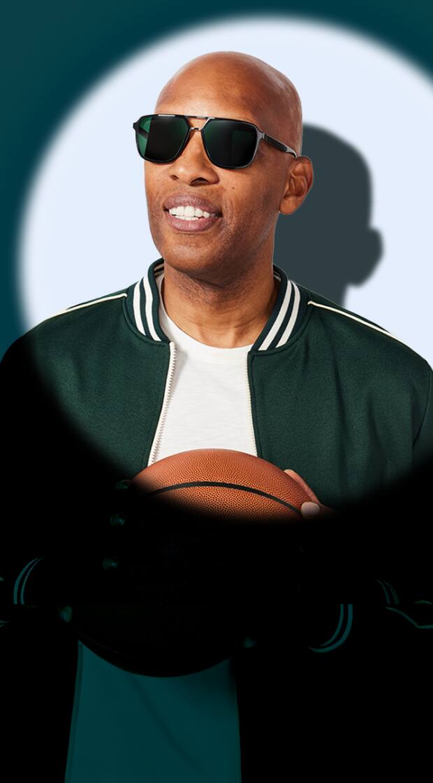 Sam Cassell holding a basketball while wearing dark rectangular sunglasses in a spotlight against a deep teal background.