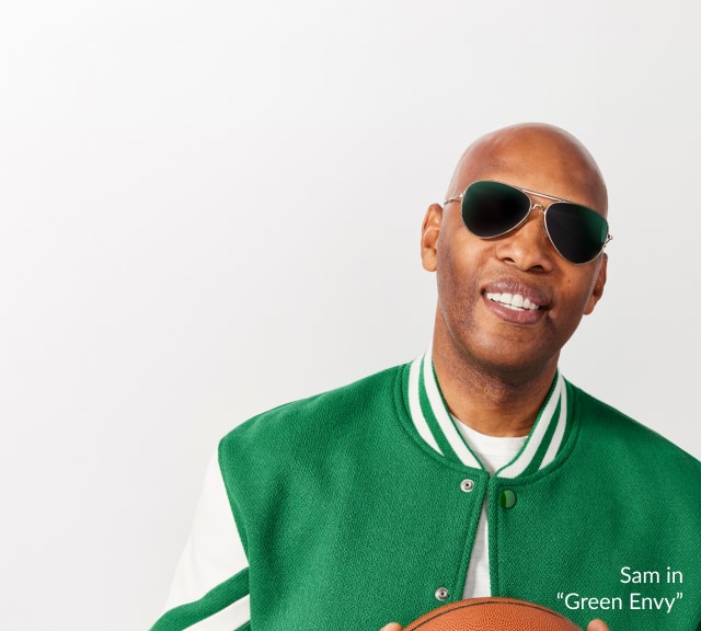 Sam Cassell grins holding a basketball, wearing 'Green Envy' sunglasses from Zenni, in a green varsity jacket.