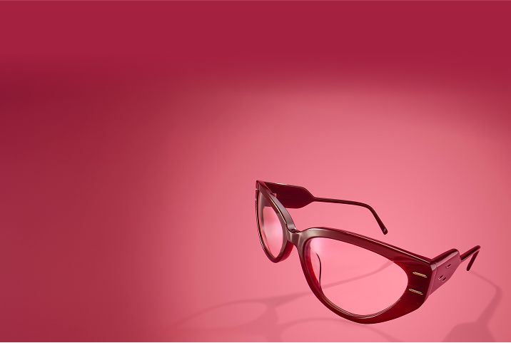 Dark red oval cat-eye glasses on a red gradient background.