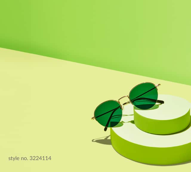 A pair of metal round sunglasses with green lenses.