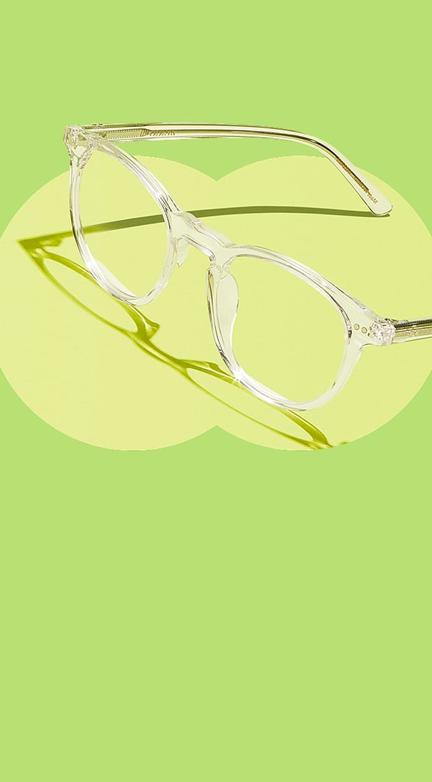 Clear round glasses on a green background.