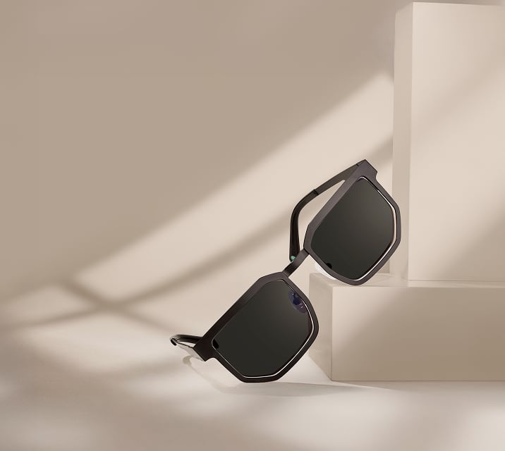 Black geometric Zenni sunglasses with dark lenses on a beige background.