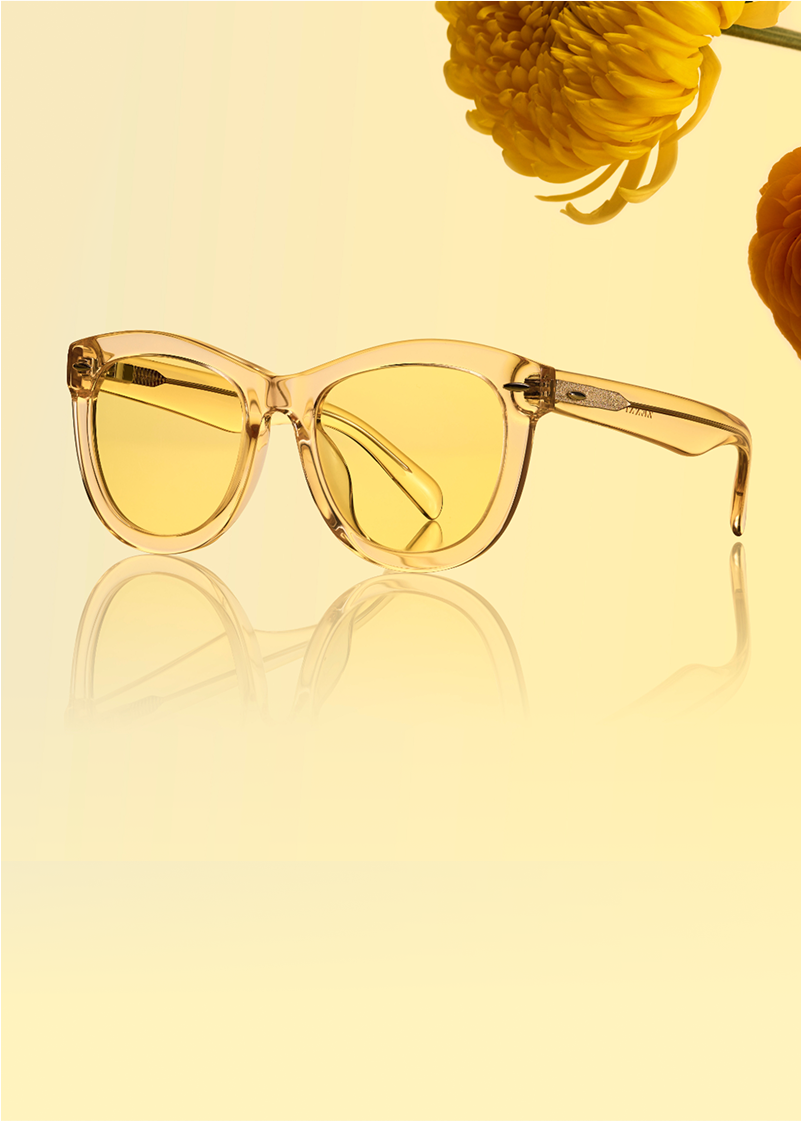 Two pairs of translucent yellow glasses are displayed beside bright yellow flowers on a soft gradient yellow background.