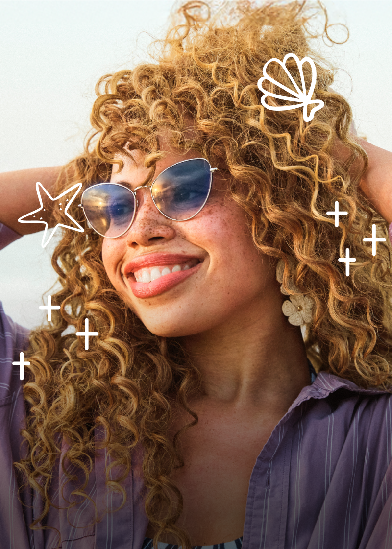Woman with curly hair and sunglasses smiling on a beach, with decorative star and seashell graphics.