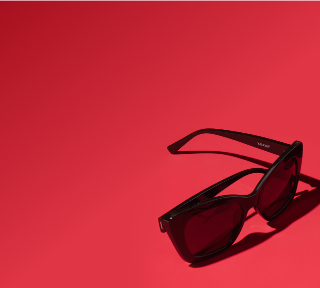 An assortment of square, round, and cat-eye polarized sunglasses on a red background.