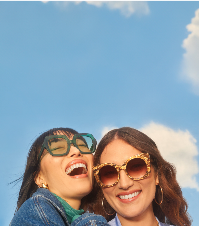 Two women smiling happily with bold Zenni sunglasses.