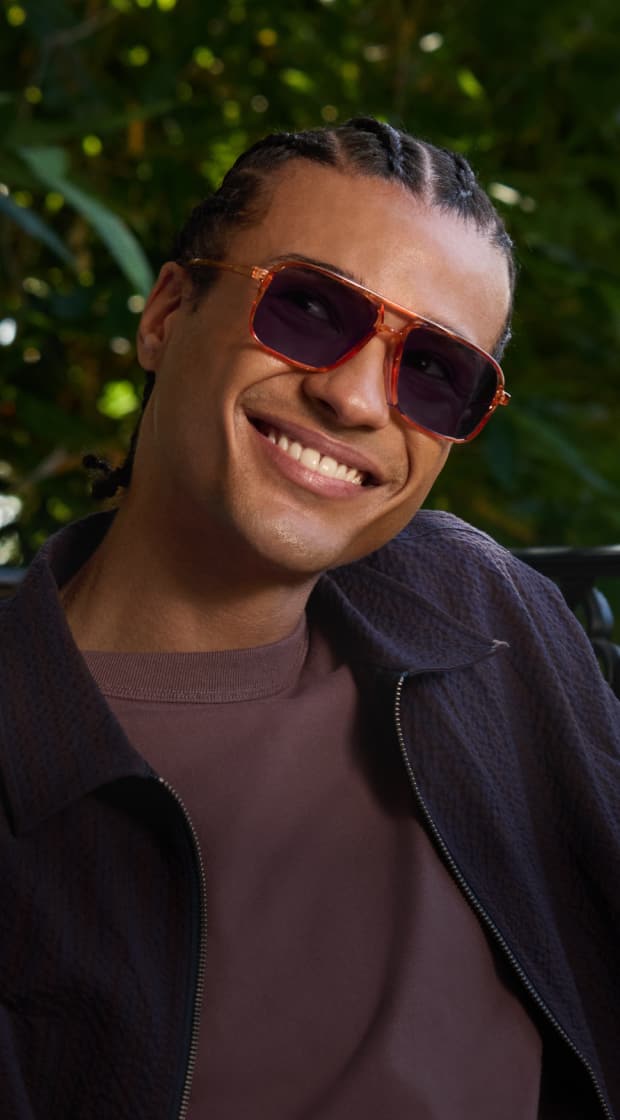 Orange square Zenni aviator sunglasses with dark lenses worn by a smiling man outdoors.