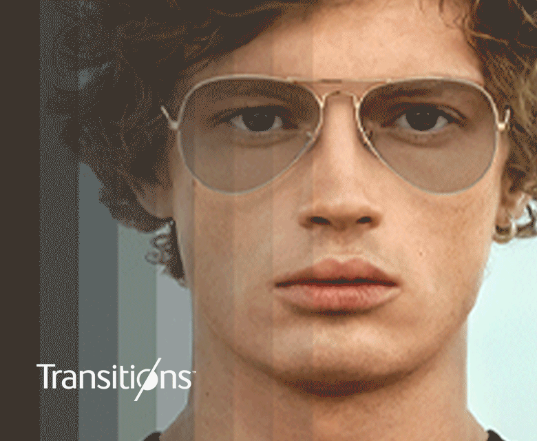 A man in gold aviator frames with Transitions lenses that go from clear to dark.