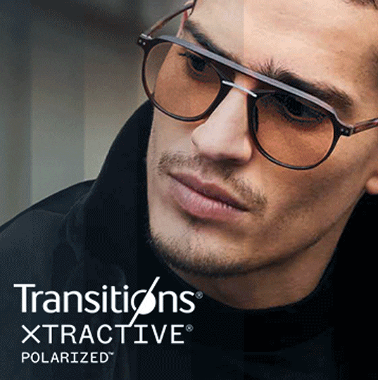 A man wearing aviator frames with Transitions lenses that go from clear to dark.
