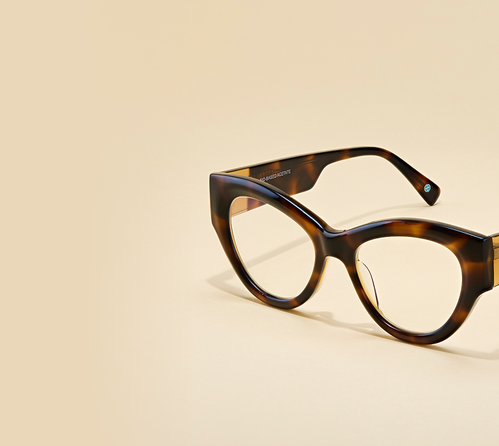 Zenni tortoiseshell cat-eye glasses on neutral beige background.