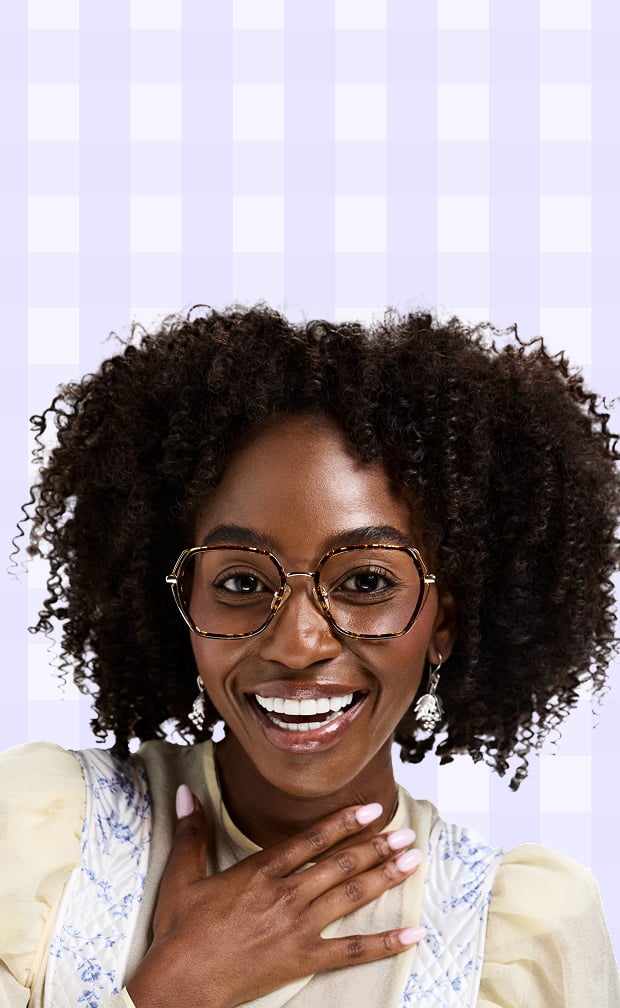 Smiling woman in Zenni cottagecore brown frames glasses with a lavender gingham background.
